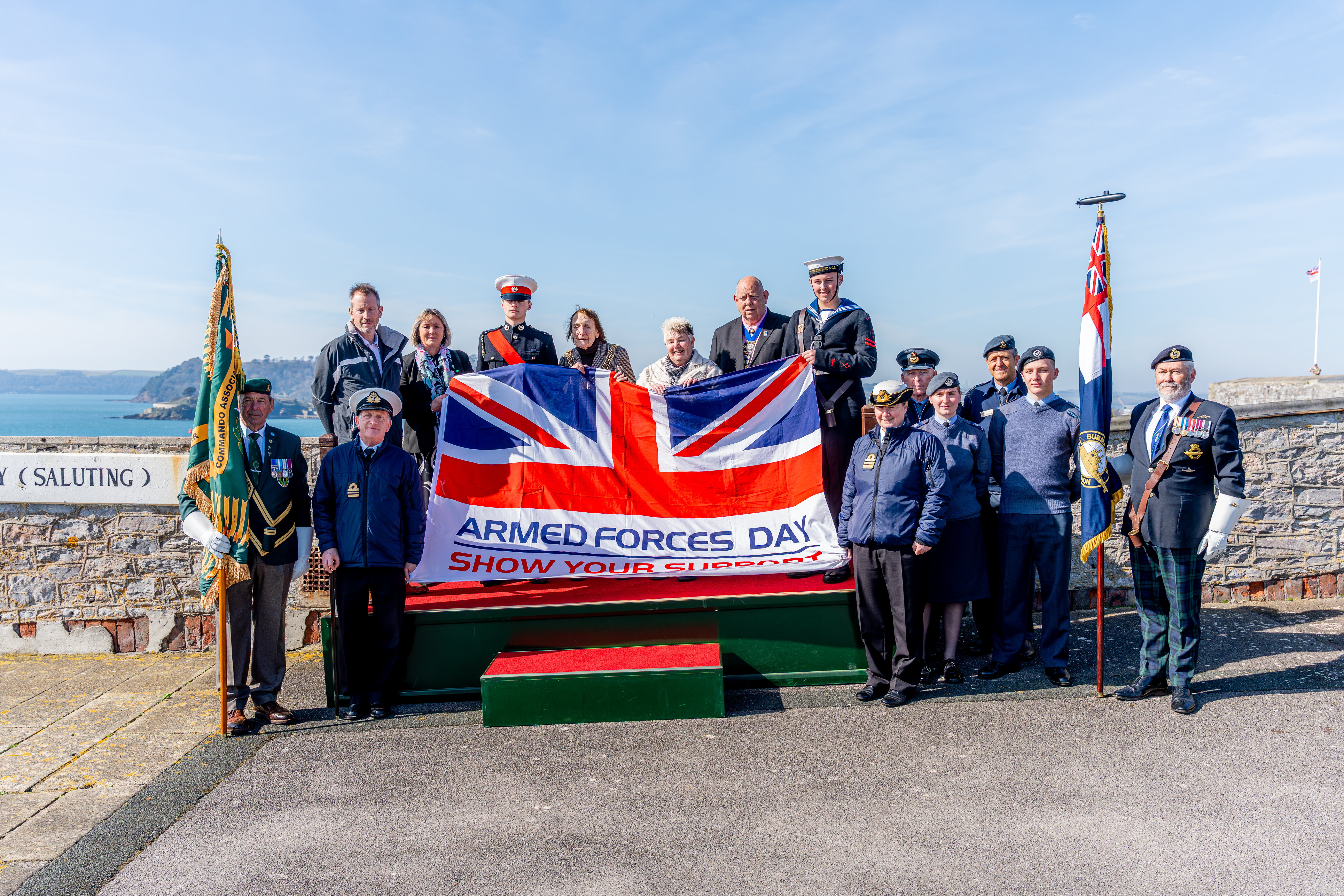 The Armed Forces Day Flag with members of Plymouth City Council, Armed Forces and Babcock behind it