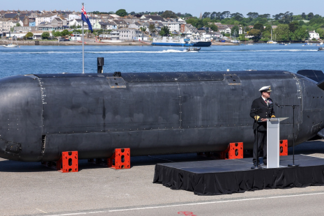 A person stood infront of a Submarine 