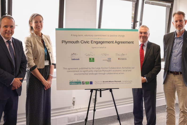 Four people stood in front of the Civic Agreement 